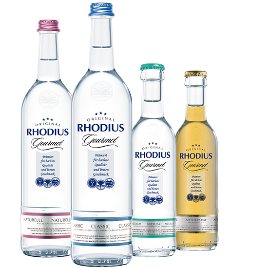 RHODIUS Gourmet ist der perfekte Begleiter zu einem guten Essen oder Wein. 4 verschiedene Flaschen RHODIUS Gourmet vor einem grauen Hintergrund.